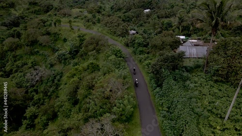 People cruising up road in Bali on scooters photo