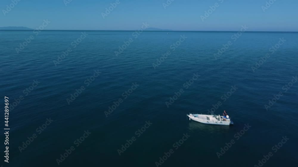 Drone flying over fishing boat in Tuscany, Italy at a sandy beach at the seaside near Alberese in the iconic Maremma nature park by sunset. Cinematic aerial footage owards the sea and ocean waves. Drone flying over fishing boat in Tuscany, Italy at a sandy beach at the seaside near Alberese in the iconic Maremma nature park by sunset. Cinematic aerial footage owards the sea and ocean waves.