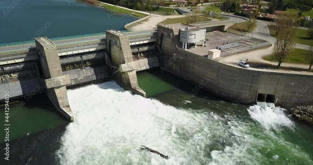 Aerial Static, Heavy water flow from an Electrical Dam over the Rhone Valley with a road above it Aerial Static, Heavy water flow from an Electrical Dam over the Rhone Valley with a road above it