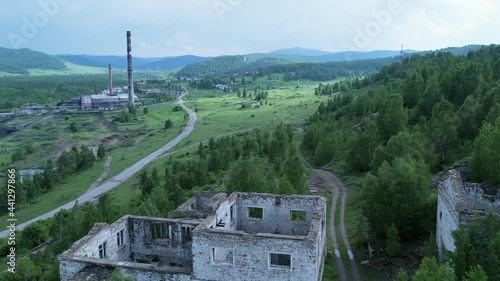 an old building of a thermal power station against the background of destroyed buildings of an abandoned factory or mine in a picturesque place in nature. Tuim, Tuimsky failure, Russia. travel and photo