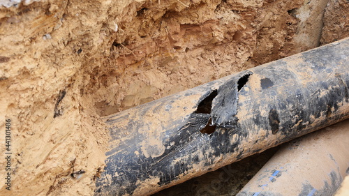 Plumbing is broken in the hole. Black plastic pipe (HDPE ) was damaged during the construction of a drainage trench with a copying area. Selective focus