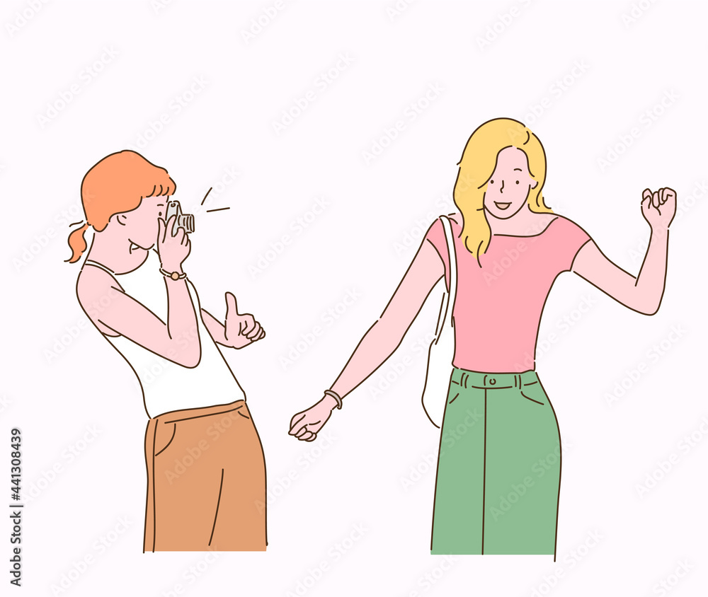 A friend is photographing another friend with a camera. hand drawn style vector design illustrations. A friend is photographing another friend with a camera. hand drawn style vector design illustrations.