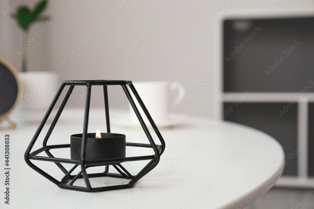 Burning candle on table in room Burning candle on table in room