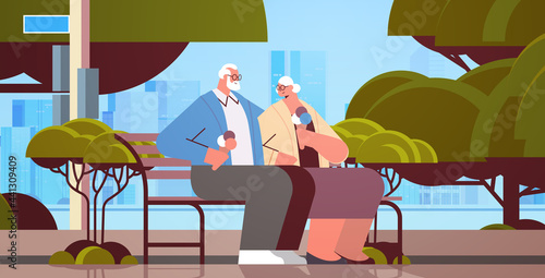senior couple sitting on bench and eating ice cream happy grandparents spending time together in park