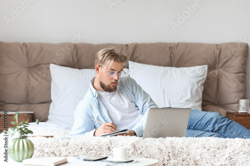 Young man studying online a...