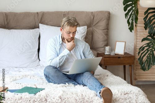 Young man studying online a...