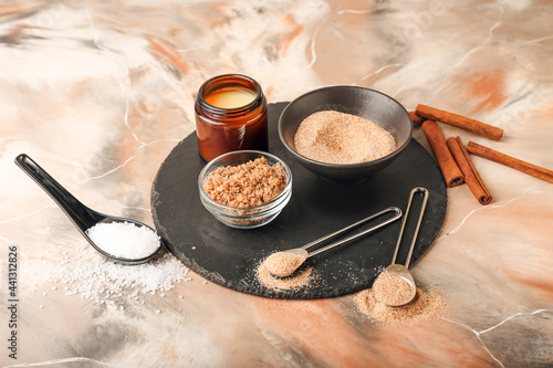 Bowl of natural scrub and ingredients on grunge background