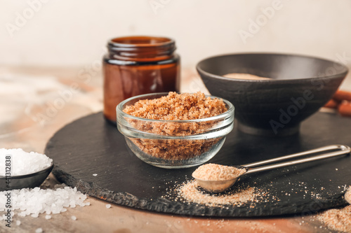 Bowl of natural scrub and ingredients on grunge background, closeup