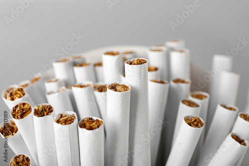 Many cigarettes on light background, closeup