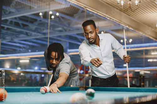 Men playing billiards in a club photo