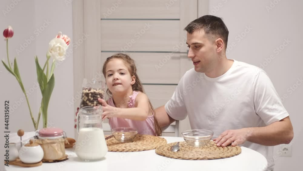 Cheerful little daughter and dad having breakfast Cheerful little daughter and dad having breakfast