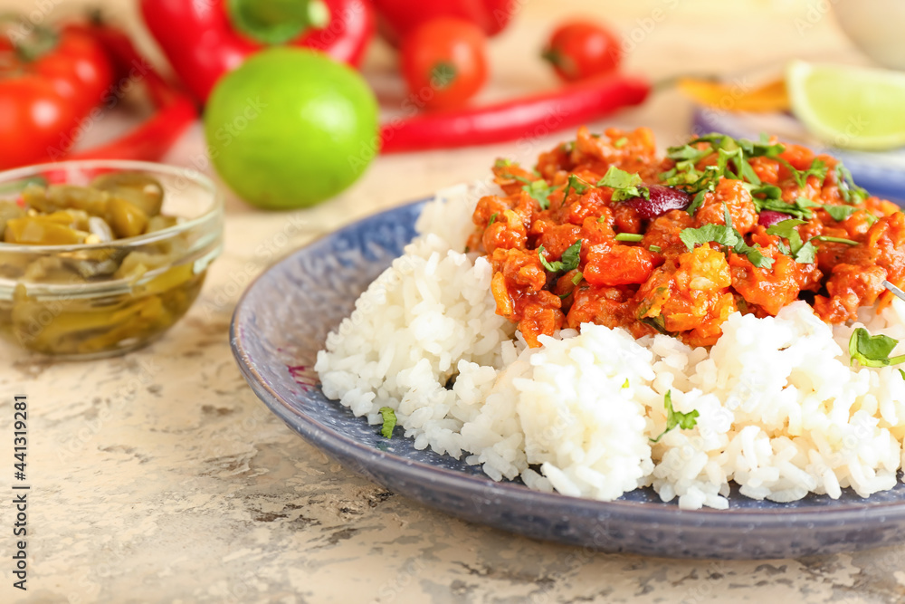 Plate with tasty chili con carne, rice and pickled jalapeno on color background, closeup Plate with tasty chili con carne, rice and pickled jalapeno on color background, closeup