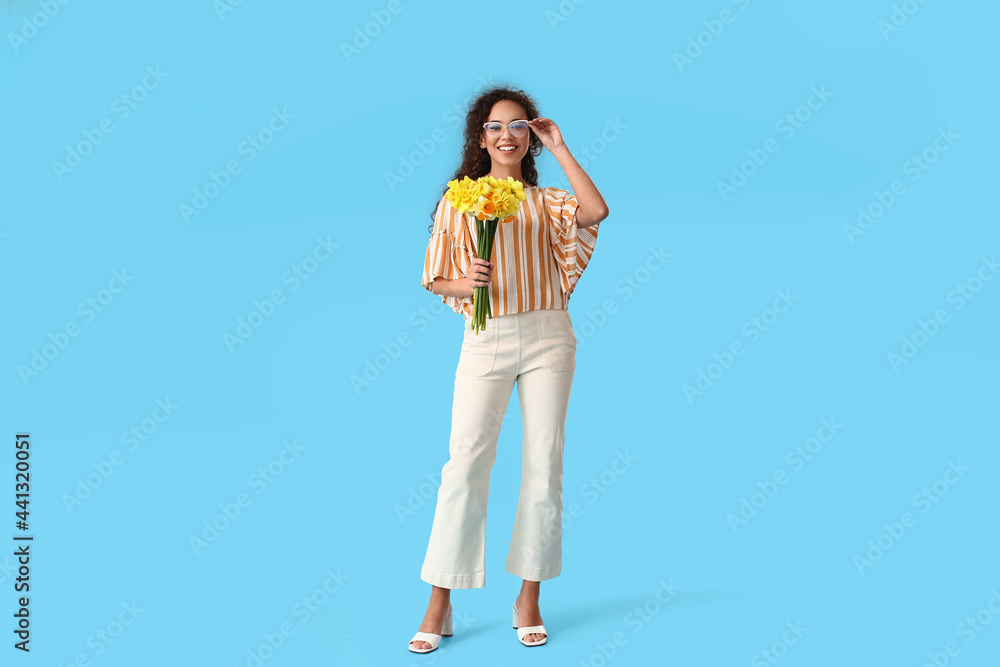 Beautiful young African-American woman with narcissus bouquet on color background Beautiful young African-American woman with narcissus bouquet on color background