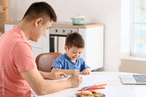 Father and his little son drawing at home