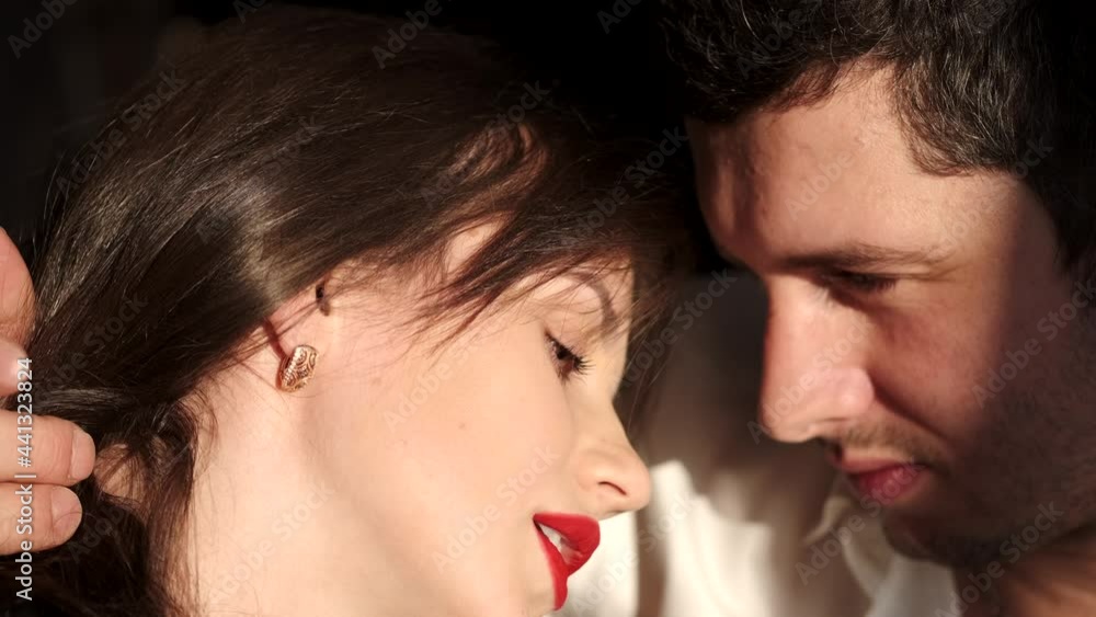 Passionate couple kissing in sunlight in a studio Passionate couple kissing in sunlight in a studio