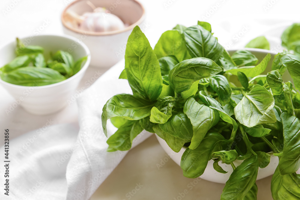Bowl with fresh basil leaves on light background Bowl with fresh basil leaves on light background