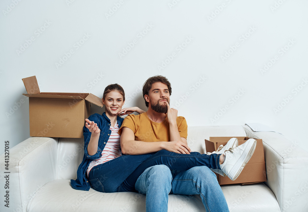 man and woman sitting on the couch moving boxes with things family housewarming man and woman sitting on the couch moving boxes with things family housewarming