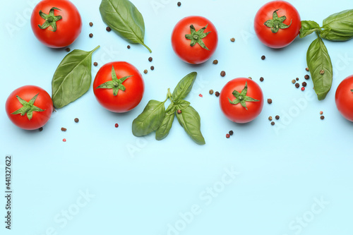Fresh ripe tomatoes, spices and basil leaves on color background