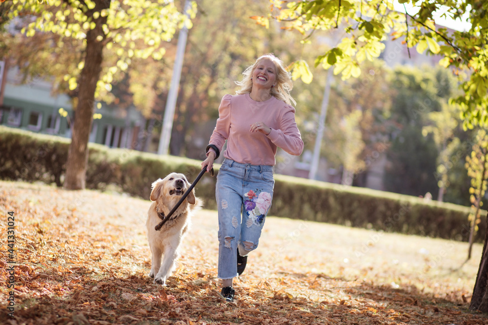 Fototapeta premium Woman running with dog in the park.