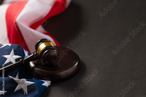 American State Flag and Judge's Gavel. Dark gray background. There is an empty space for your signature. There are no people in the photo. Minimalism.
