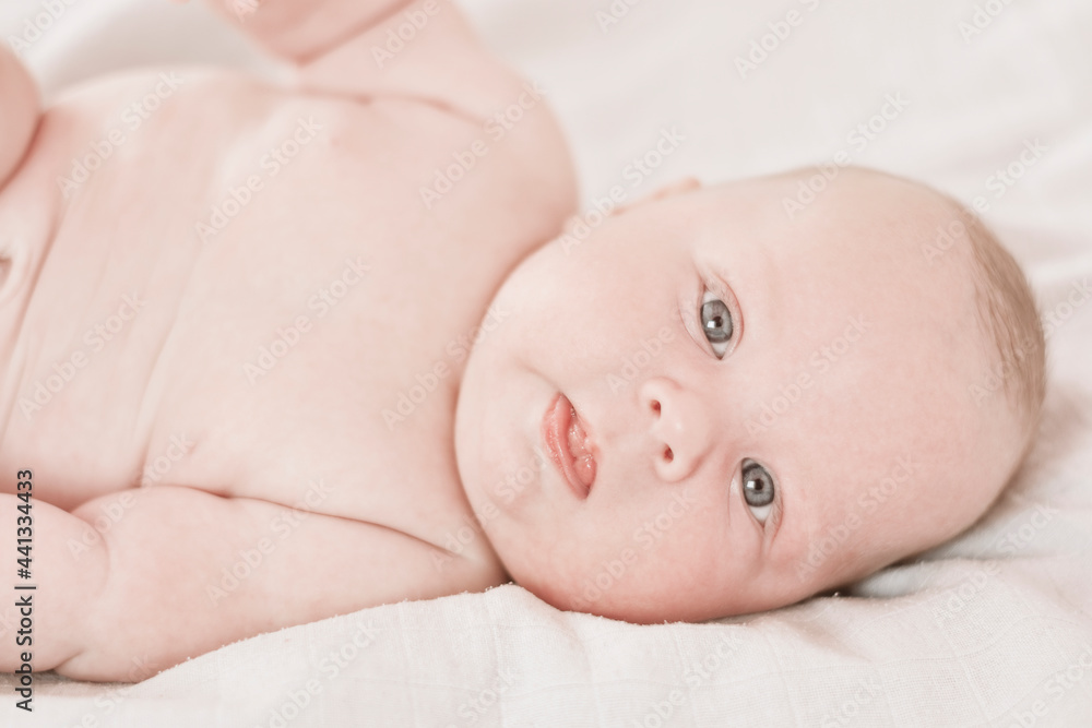 Three months old Caucasian infant lies on a white mat. Three months old Caucasian infant lies on a white mat.