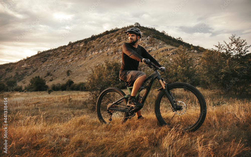 Active man riding electric mountain bike in nature