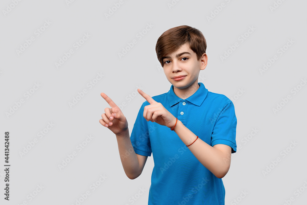 Handsome boy looking at the camera and showing aside on copyspace. Pay attention to important information Handsome boy looking at the camera and showing aside on copyspace. Pay attention to important information