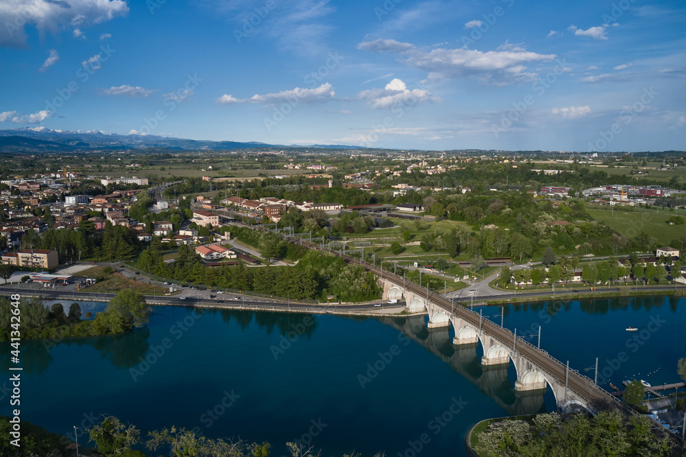 Panoramic aerial view of the railway bridge over the river. Peschiera del Garda, Italy. Aerial view of the resort town on Lake Garda.