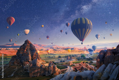 Beautiful morning hot air balloon flight against backdrop of starry sky over Cappadocia, Turkey.