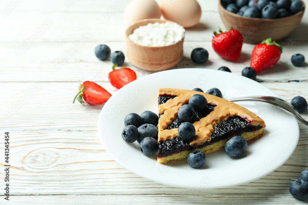 Concept of delicious dessert with blueberry pie on white wooden table