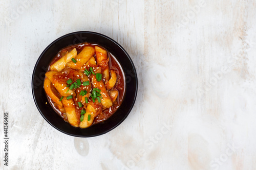 Top view Tteokbokki (Spicy Rice Cakes) on the white wooden table, Korean street food.