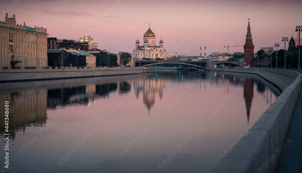 View of the Moscow towers and cathedrals and reflections on the Moscow River in an early sunny golden morning