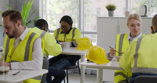 Diverse factory workers having lunch in canteen