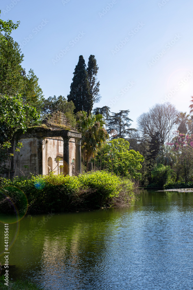 Pond in the English Garden of the Royal Palace in Caserta. In the middle is a small island with an old temple with columns. Caserta, Italy
