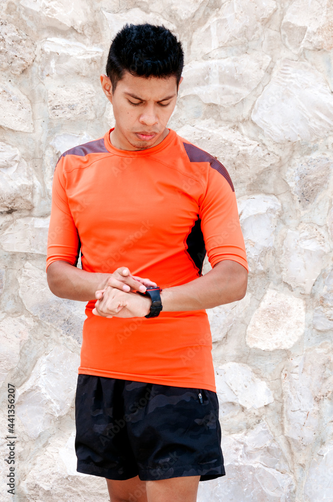 Runner setting up his sports watch to start his run Runner setting up his sports watch to start his run