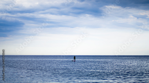 One man achieving balance while paddle surfing in calm waters of de mediterranean sea © GonzaloVega