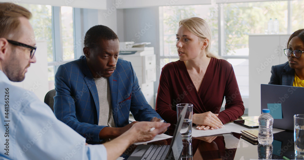 © TommyStockProject - Serious african executive listening to employees report looking at tablet screen © TommyStockProject - Serious african executive listening to employees report looking at tablet screen
