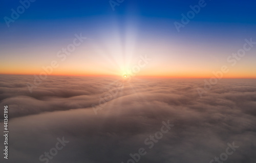 View from the drone at dawn over the clouds with mountains on the grassland.