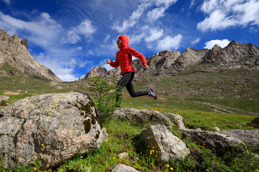Woman ultra marathon trail runner running on beautiful mountains