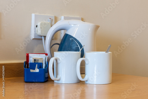 Basic tea and coffee making facilities in a hotel with electric kettle, mugs, spoons, tea, coffee and milk
