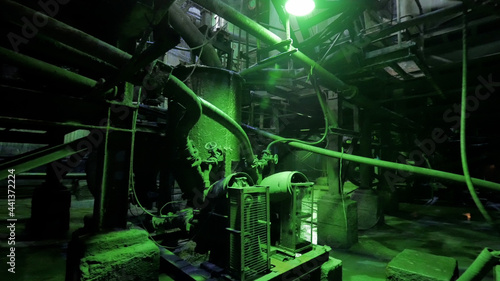 Abandoned industrial interior in dark colors with glowing green lights