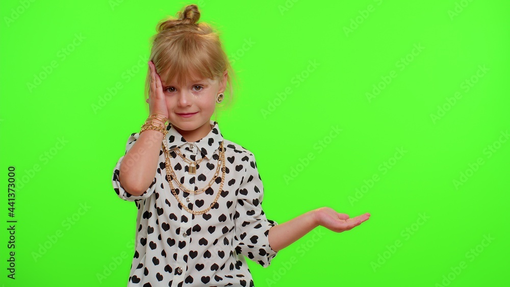 Funny playful blonde kid child showing thumbs up and pointing empty place, advertising area for commercial text, copy space for goods promotion on chroma key background. Cute teenager children girl Funny playful blonde kid child showing thumbs up and pointing empty place, advertising area for commercial text, copy space for goods promotion on chroma key background. Cute teenager children girl
