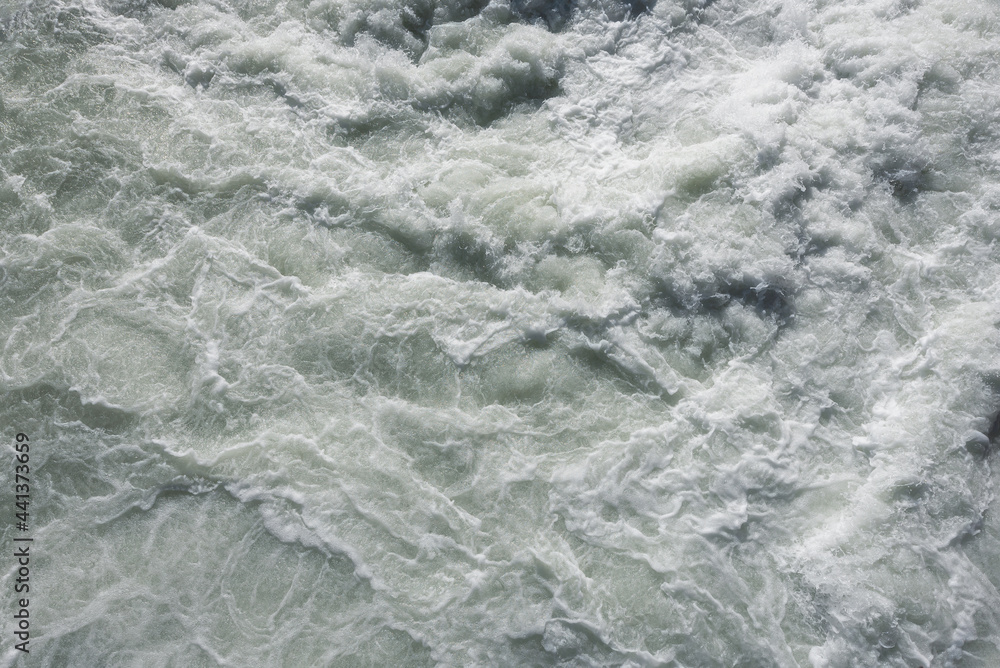 Water texture background. Sea waves with white foam.