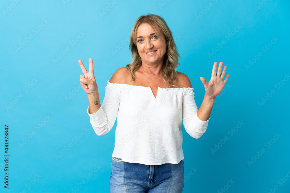 Middle aged blonde woman over isolated background counting seven with fingers Middle aged blonde woman over isolated background counting seven with fingers