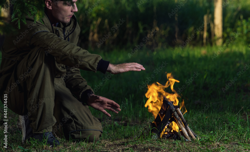 a man in a protective suit next to a bonfire
