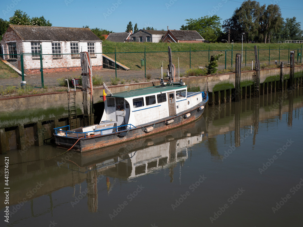Old weathered boat lies longest on the quay wall and reflects in the water Old weathered boat lies longest on the quay wall and reflects in the water