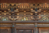 Japanese buddhist three-story timber pagoda of gotokuji zen temple adorned with carved manekineko cat meaning beckoning cat and astrological signs on the wooden brackets.