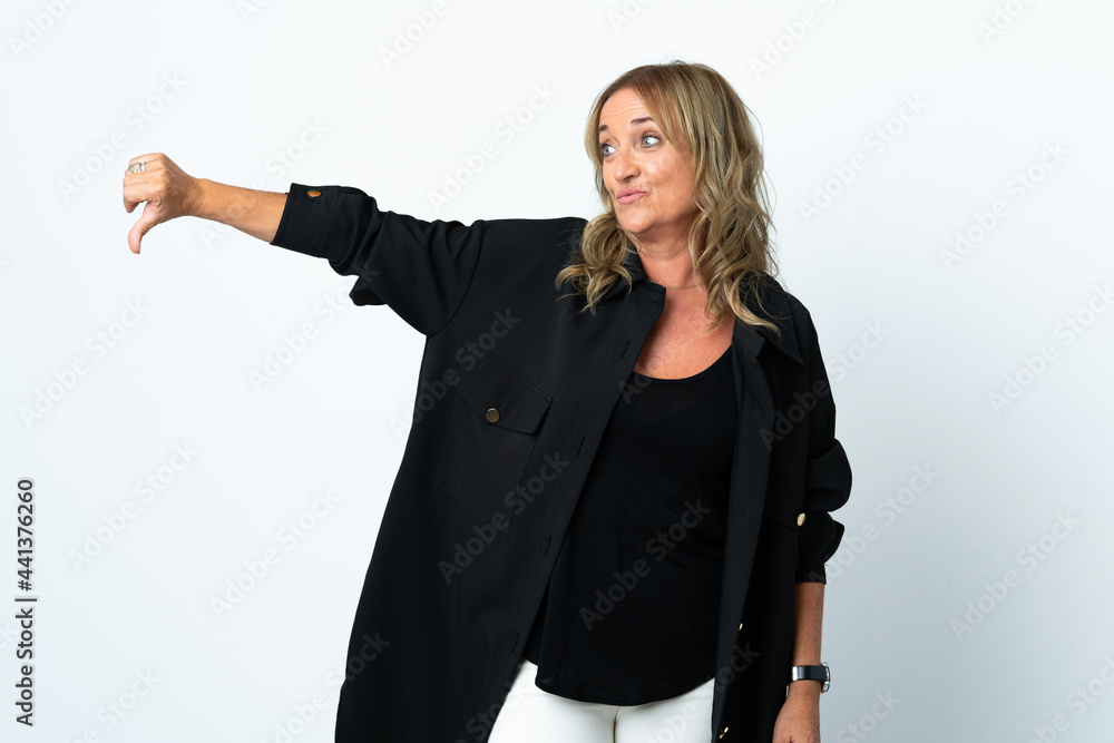 Middle aged blonde woman over isolated white background showing thumb down with negative expression Middle aged blonde woman over isolated white background showing thumb down with negative expression