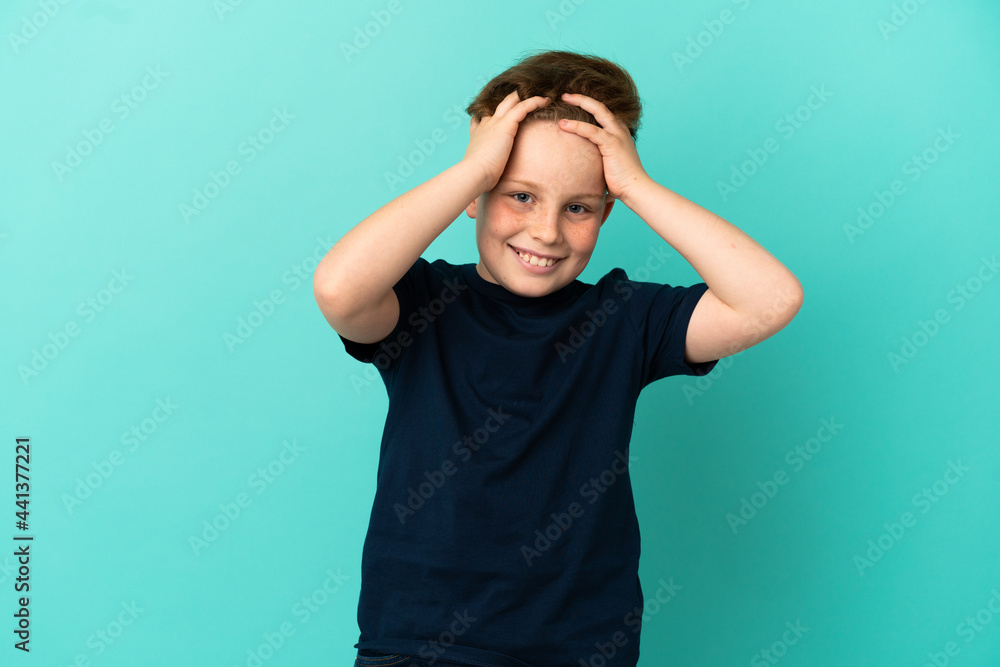 Little redhead boy isolated on blue background laughing Little redhead boy isolated on blue background laughing