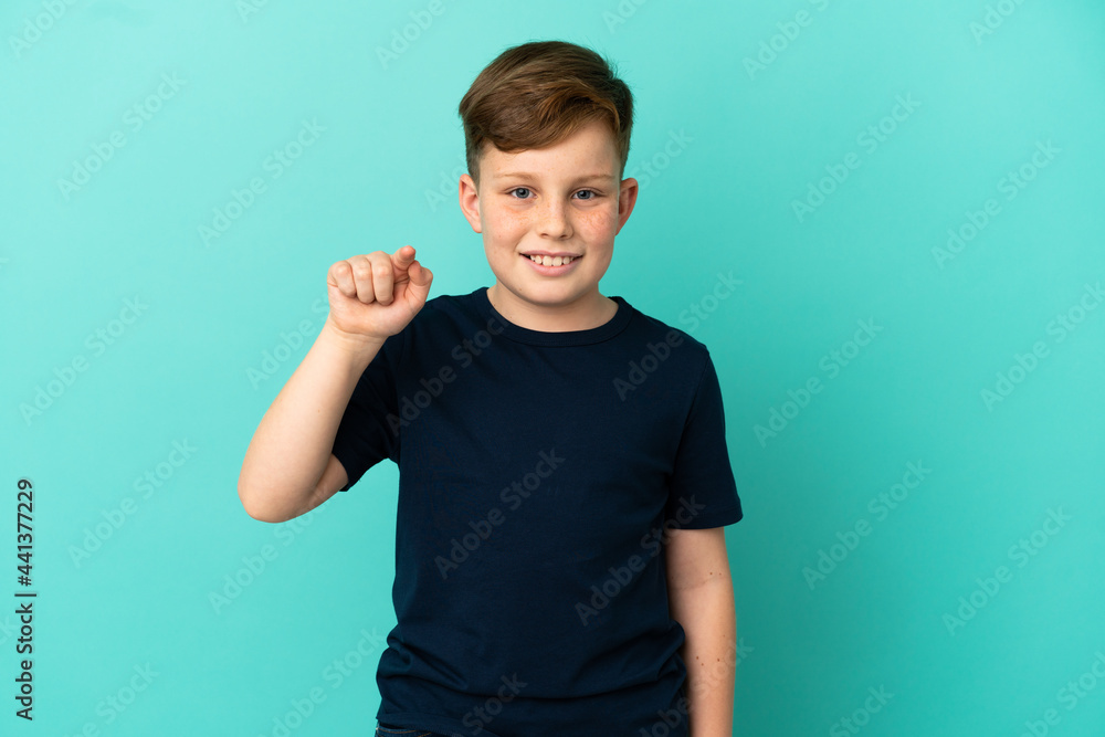Little redhead boy isolated on blue background surprised and pointing front Little redhead boy isolated on blue background surprised and pointing front